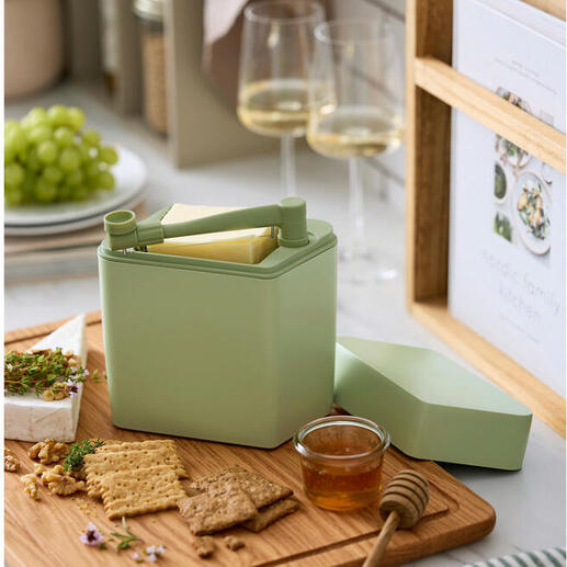 Boîte de fraîcheur pour fromage avec coupeur sur une planche en bois à côté de crackers et de miel.
