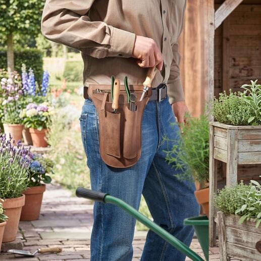Homme portant une ceinture à outils en cuir de buffle, remplie d'outils de jardin.