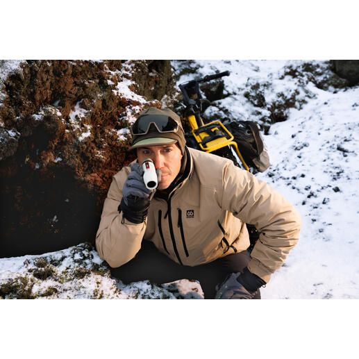 Homme observant avec un monoculaire dans les montagnes pendant la neige.