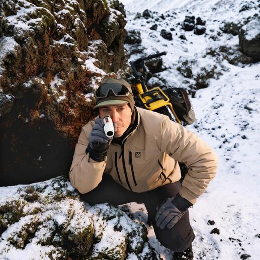 Homme observant avec un monoculaire dans les montagnes pendant la neige.