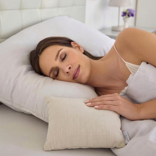 Une femme dort paisiblement avec un petit coussin anti-moustiques sur un plus grand oreiller.