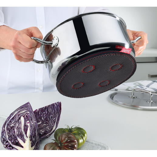 Main tenant un sous-plat magnétique sous une casserole.