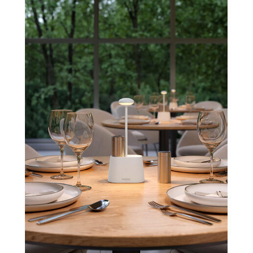 Lampe à poivre et sel blanche sur une table extérieure avec de la décoration.