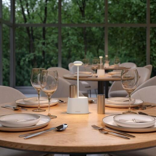 Lampe à poivre et sel blanche sur une table extérieure avec de la décoration.