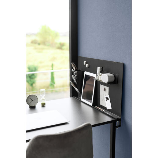 Tableau magnétique noir avec des accessoires de bureau sur un bureau.