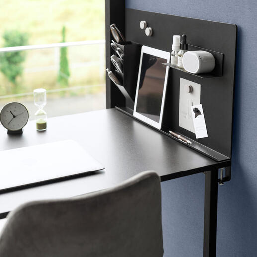 Tableau magnétique noir avec des accessoires de bureau sur un bureau.