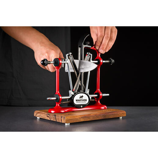 Aiguiseur de couteaux professionnel rouge utilisé par une main.