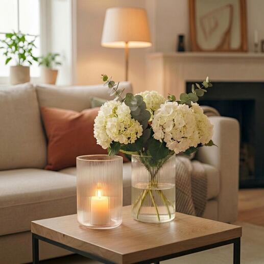 Deux vases avec des fleurs blanches et de la lumière dans un espace de vie moderne.