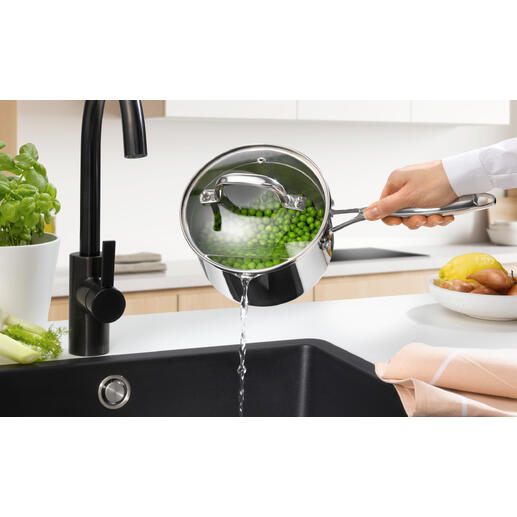 Casserole à long manche avec couvercle, de l'eau est versée dans l'évier.