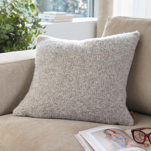 Coussin en alpaga-lin sur un canapé clair avec des lunettes et un magazine.