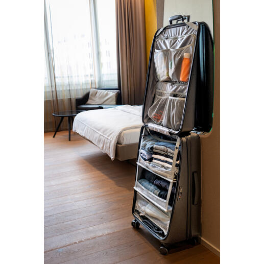 Valise dans une chambre d'hôtel, ouverte avec des vêtements et des accessoires.