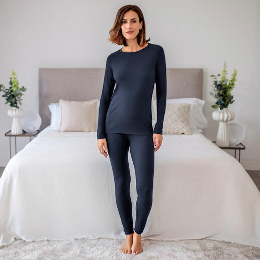 T-shirt de pyjama pour femmes en bleu foncé, se tenant décontracté devant un lit.