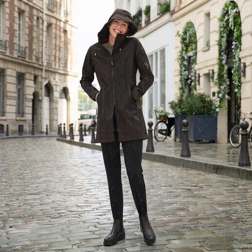 Femme en imperméable noir sur une rue pluvieuse