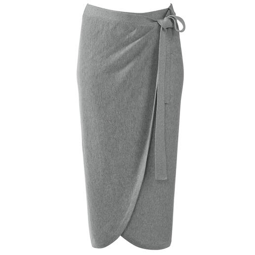 Femme en jupe ou pull en alpaga Pima marchant au bord de la rue avec un sac.