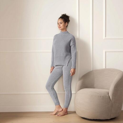 Femme portant un pull en merinos gris et un legging dans une pièce lumineuse