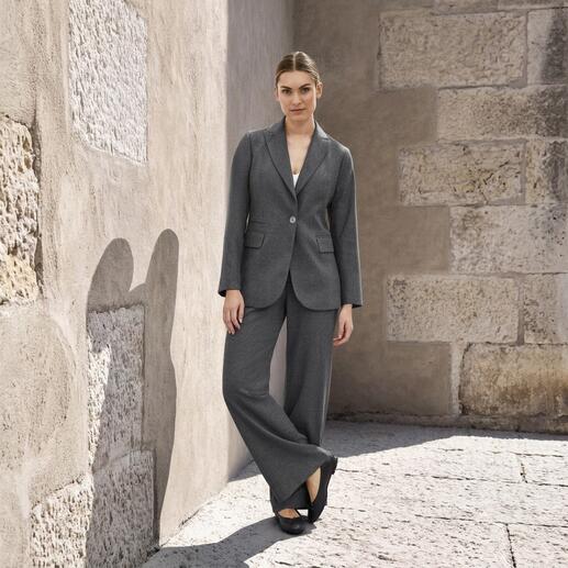 Femme en blazer et pantalon gris dans la rue
