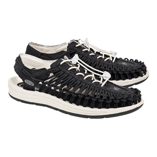 Une paire de sandales Uneek de KEEN en noir et blanc sur fond blanc.