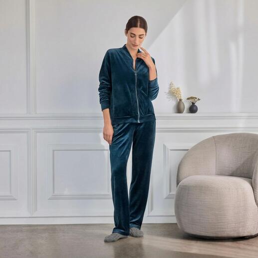 Femme portant un ensemble en velours Hanro vert, détendue dans un environnement moderne.