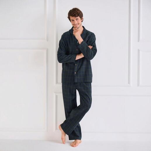 Homme en pyjama en flanelle à carreaux, debout les bras croisés.