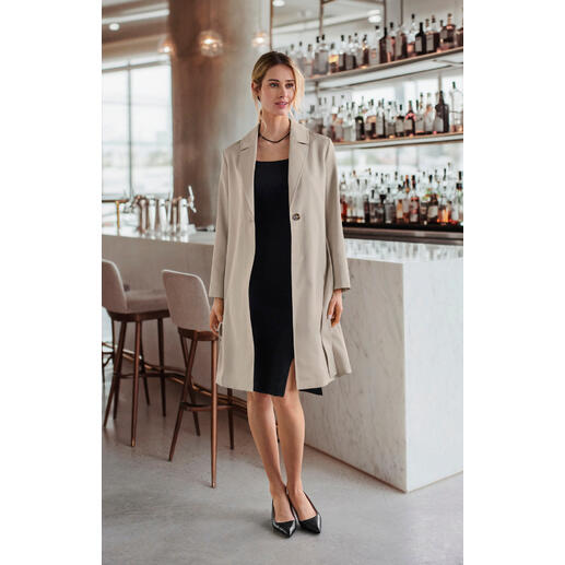 Manteau en soie et alpaga Clark Ross Femme en manteau en alpaga-soie beige dans un bar élégant.