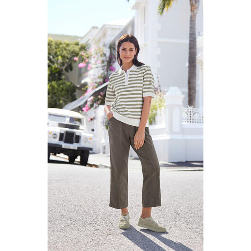 Beige Femme portant un polo rayé et un pantalon décontracté dans un environnement urbain.