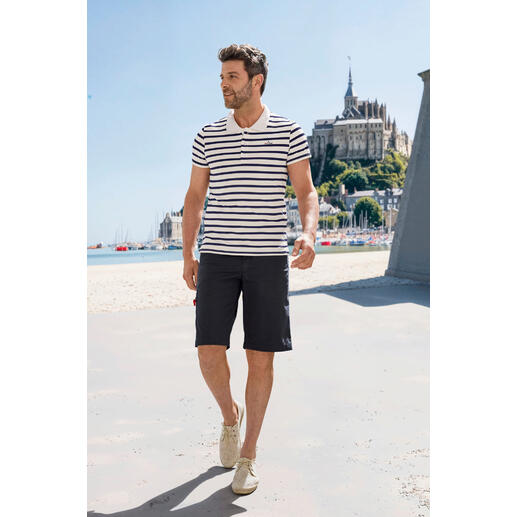 Polo de Bretagne Saint James Homme en polo à rayures Saint James Bretagne, marchant sur la plage.