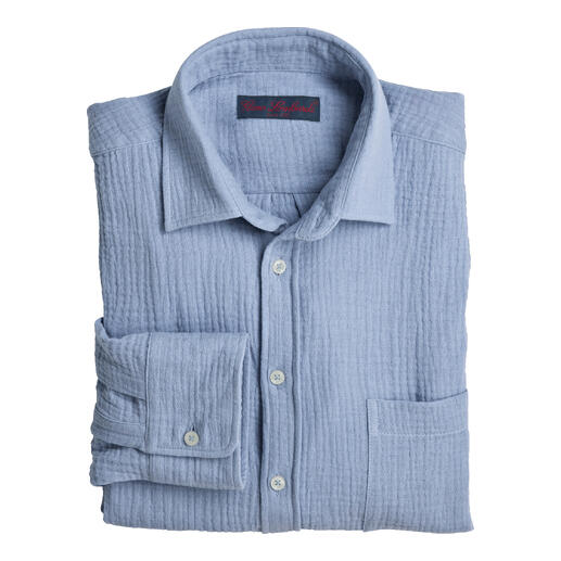 Chemise en mousseline bleu clair, soigneusement pliée avec une patte de boutonnage.