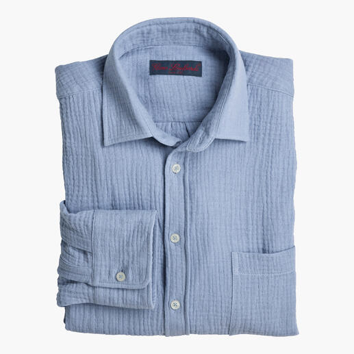 Chemise en mousseline bleu clair, soigneusement pliée avec une patte de boutonnage.