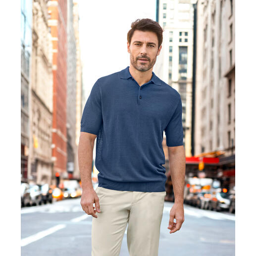Polo en piqué et soie Junghans 1954 Homme en polo piqué bleu marine, posant dans la rue.