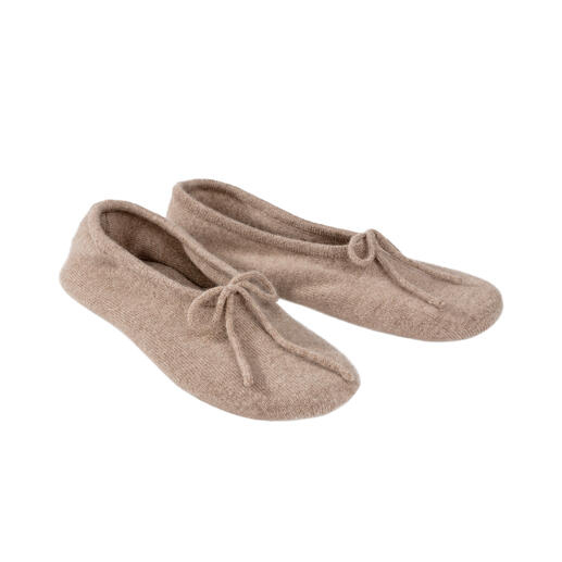 Deux chaussons de voyage en cachemire beige clair côte à côte.