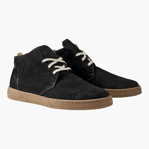 Chaussures chukka ultralégères noires avec lacets clairs sur fond neutre.