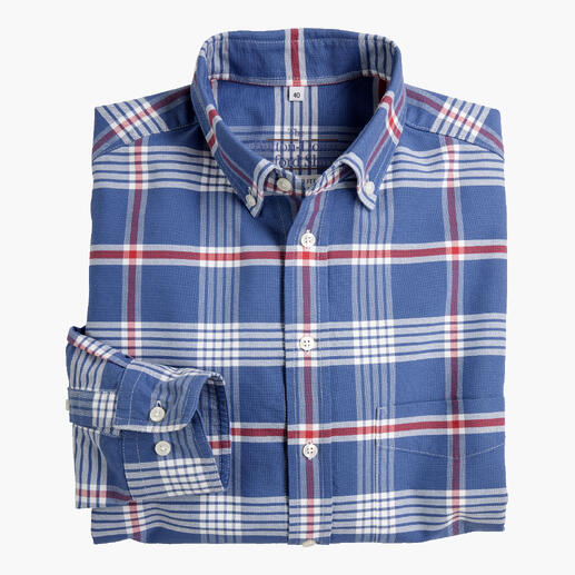 Chemise à carreaux bleus soigneusement pliée avec des boutons