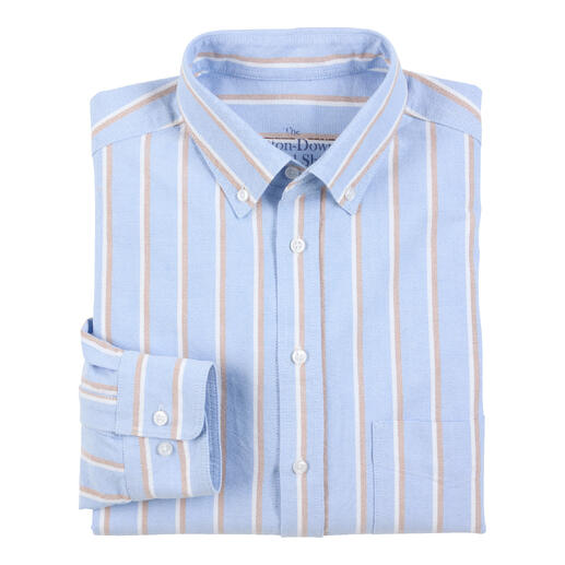 Chemise bleue avec des rayures blanches et brunes, pliée sur un fond blanc.