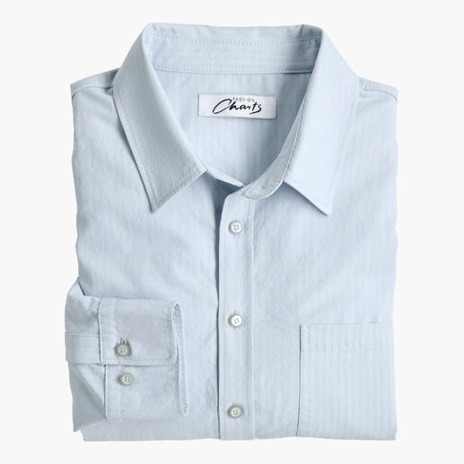 Chemise en lyocell seersucker bleu clair, soigneusement pliée, avec boutons et col classique.