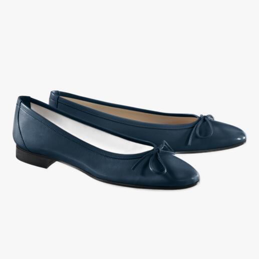 Ballerines navy avec nœud sur un fond clair.
