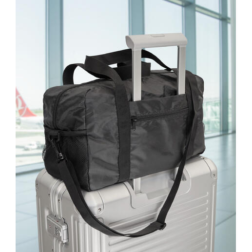 Sac de voyage pliable exclusif sur une valise à l'aéroport.