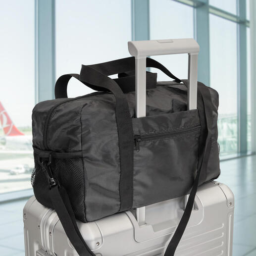 Sac de voyage pliable exclusif sur une valise à l'aéroport.
