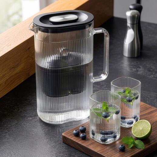 Carafe filtrante avec un verre supplémentaire et des herbes fraîches.