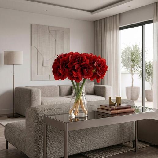 Bouquet d'amaryllis généreux dans un vase sur une table en verre avec un canapé en arrière-plan.