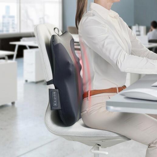 Appareil de massage du dos fixé à une chaise de bureau pendant qu'une personne travaille.