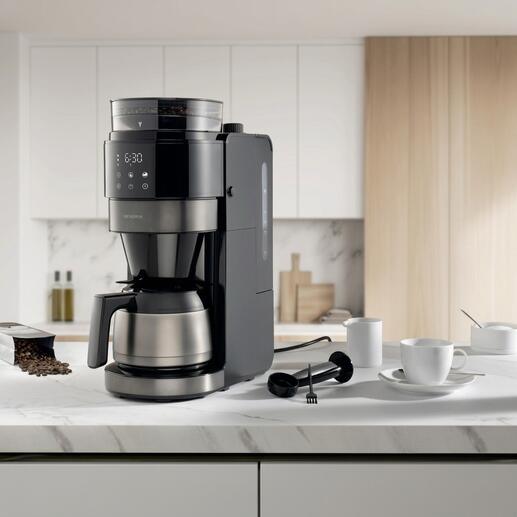 Machine à café filtre premium dans une cuisine moderne avec accessoires.