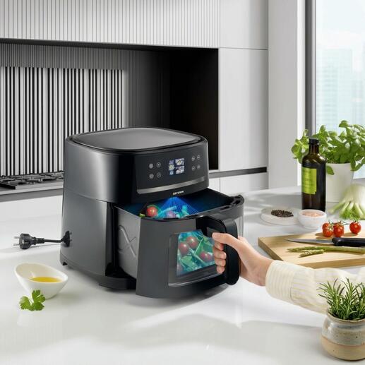 Airfryer avec technologie IA dans une cuisine moderne, aliments en préparation.
