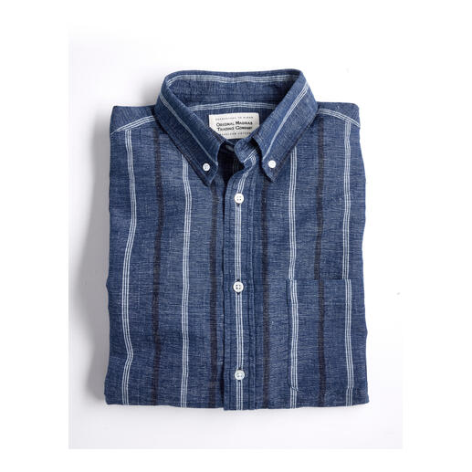Chemise en chambray de chanvre pliée sur un fond blanc.