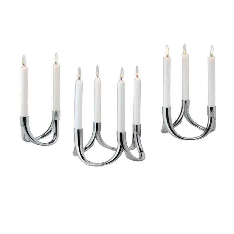 Emboîtez deux arcs ensemble : voici un chandelier à deux flammes délicat, parfait pour un dîner romantique en tête à tête. Ou bien, vous doublez les arcs : idéal pour une langue table étroite ou votre buffet. Emboîtez 3 arcs les uns aux autres: cette forme triangulaire chic décorera toutes les tables rondes, ovales et rectangulaires. Emboîtez les arcs en cercle. ornés de 4 bougies, voici un centre de table élégant. Bougeoir Bow, dans différentes vues, montrant divers designs avec des bougies.