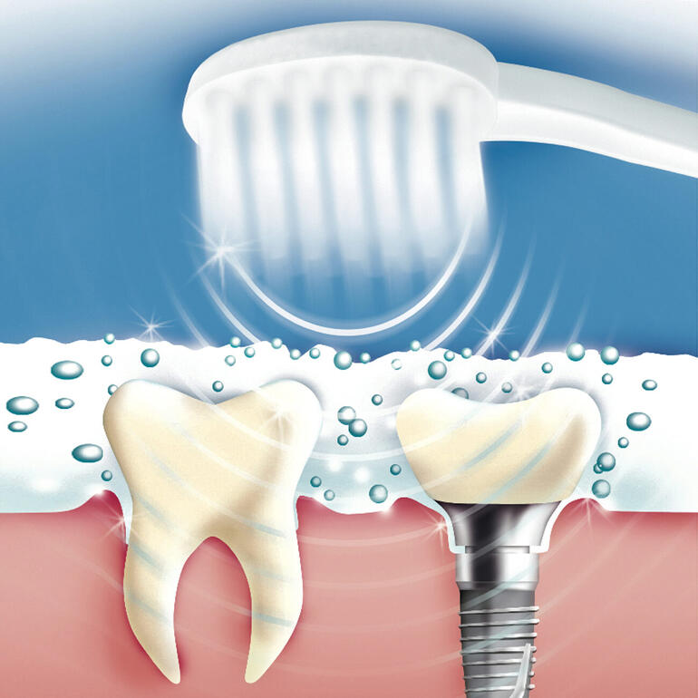 Brosse à dents avec technologie sonore nettoie les dents au-dessus d'un jet d'eau.