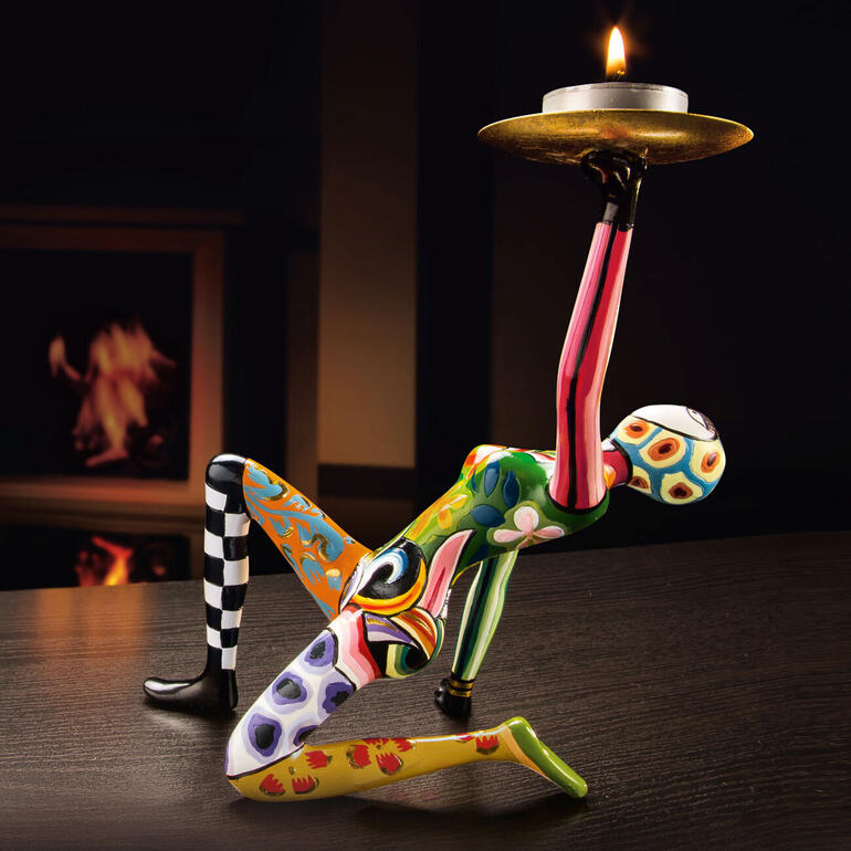 Sculpture colorée de Tom avec une bougie sur une table.