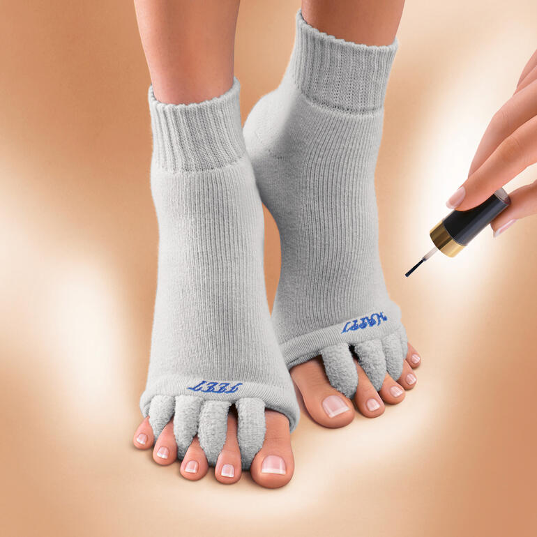 Chaussettes bien-être grises avec orteils ouverts pour appliquer du vernis.