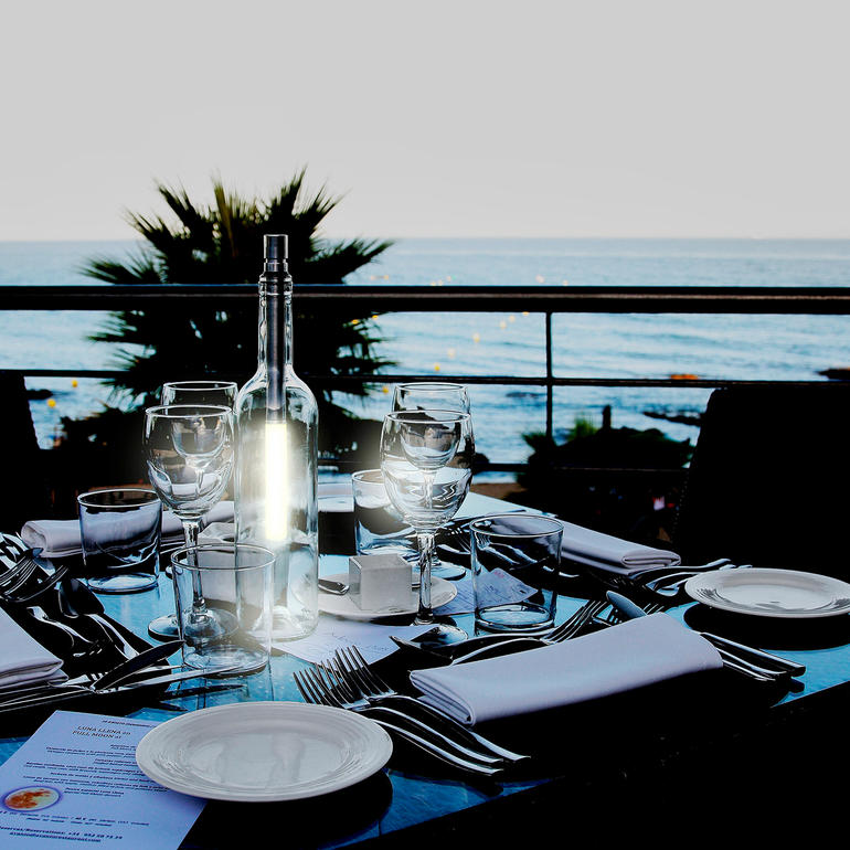 Bouteille en verre sur une table avec vue sur la mer.