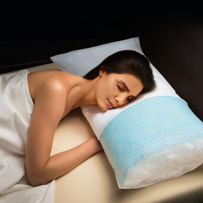 Des microcapsules de PCM imperceptiblement intégrées dans l’intissé frais absorbent la chaleur corporelle excédentaire et l’évacuent vers l’extérieur du corps. Femme allongée sur un coussin Hefel Cool, dans une position détendue.