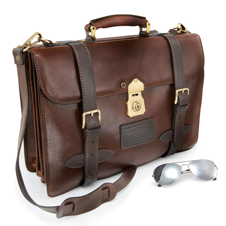 Malette brune avec des lunettes de soleil sur une table